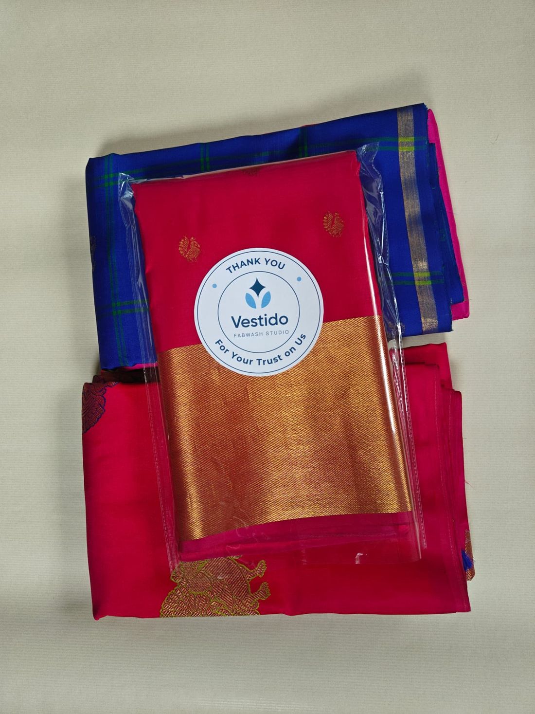Pink and blue silk sarees roll polished and sealed with the Vestido Fabwash Studio thank-you seal