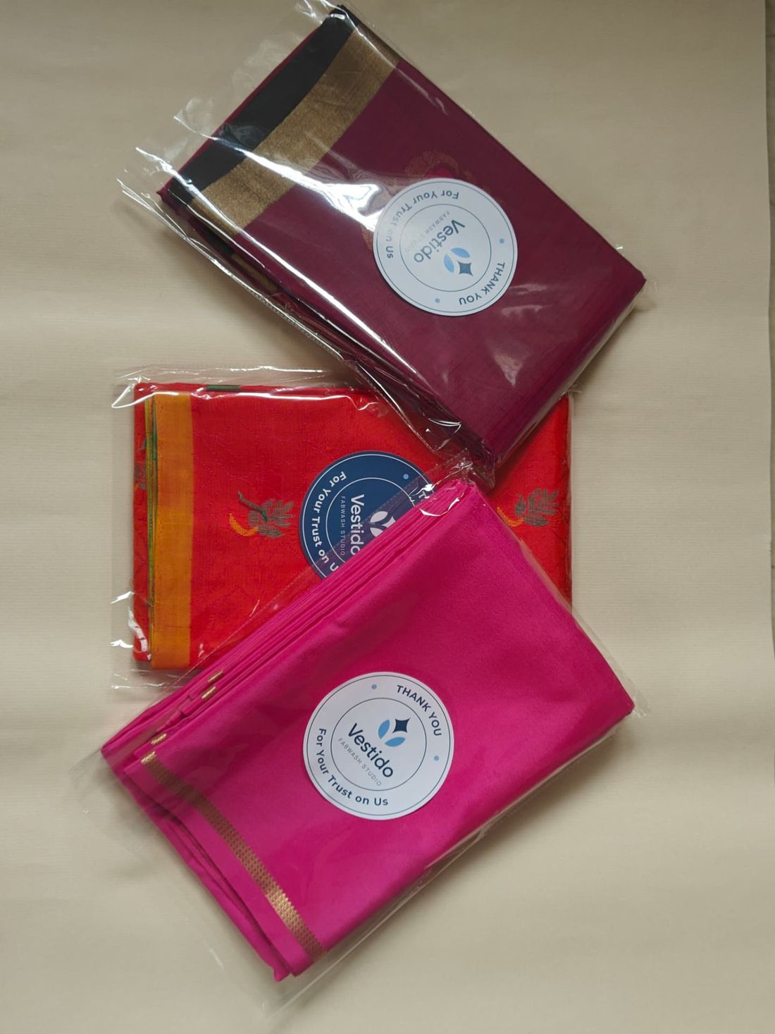 Three roll-polished silk sarees packed and sealed at Vestido Fabwash Studio