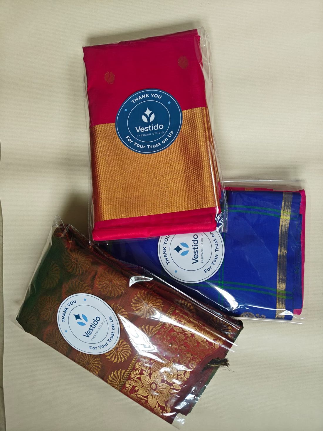 Zari-bordered silk sarees restored by saree roll polishing and sealed in protective covers